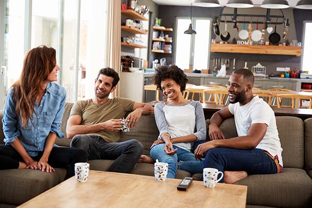 A group of smiling adults in a living room