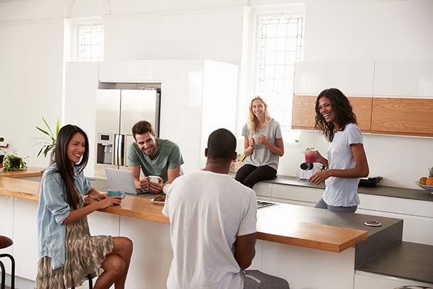 A group of smiling adults in a kitchen